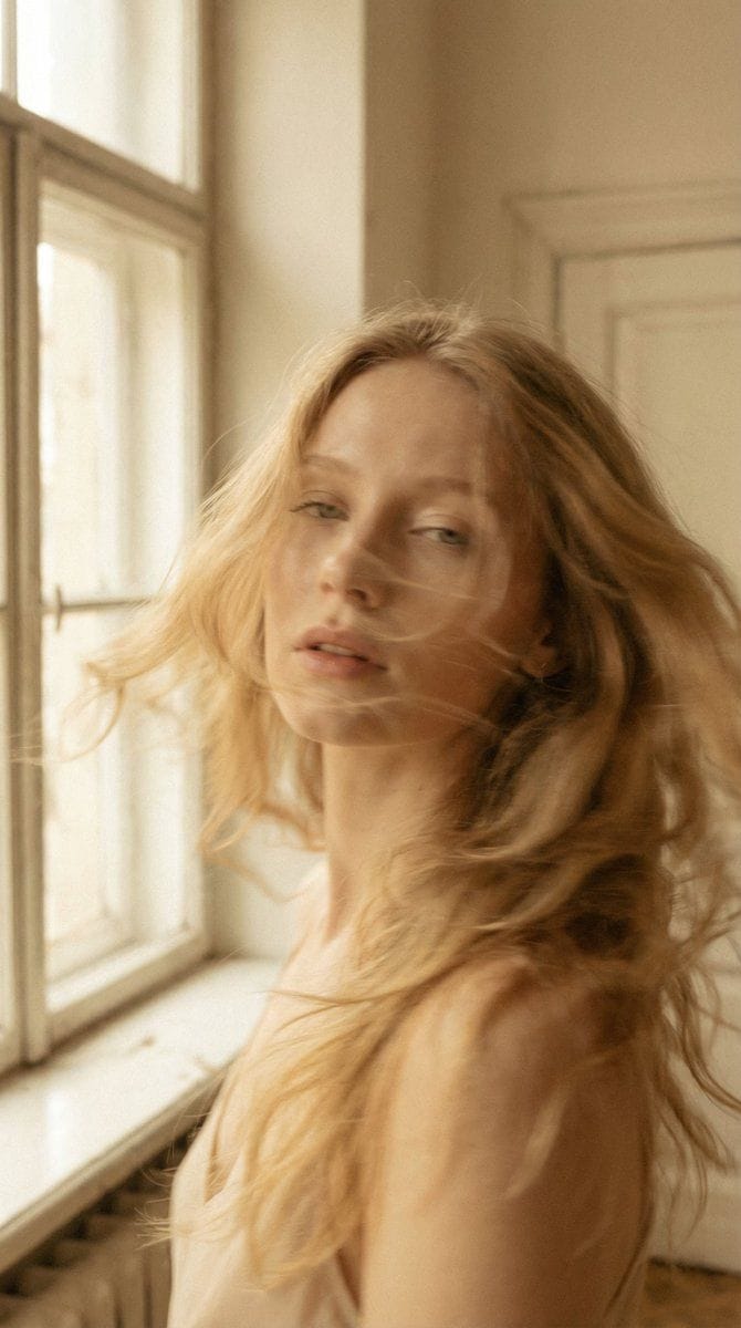 Cinematic portrait of woman with flowing golden hair and dreamy blur